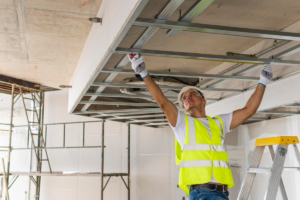 A man measuring the interior of a commercial building during a remodeling project
