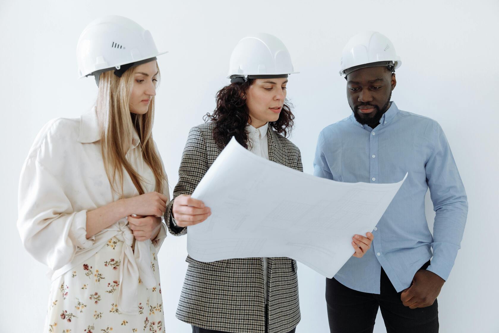 Three people looking at the commercial building remodel plan