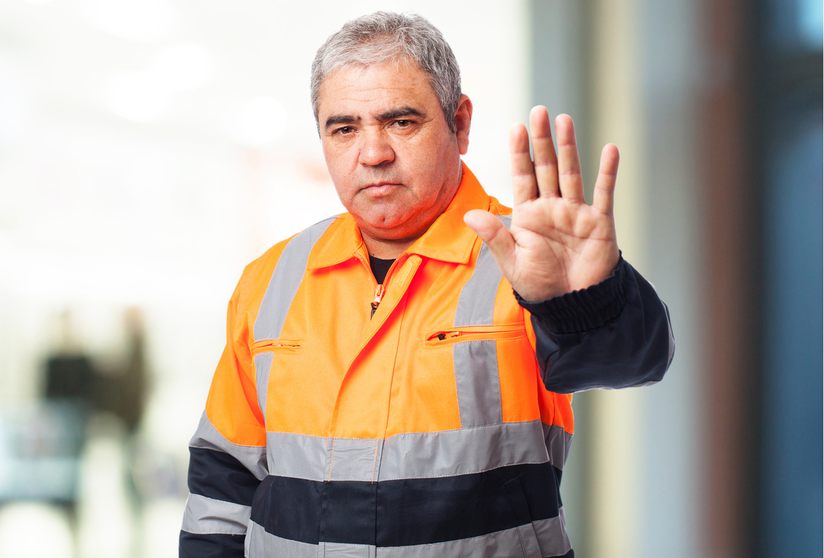 A man in uniform signaling stop